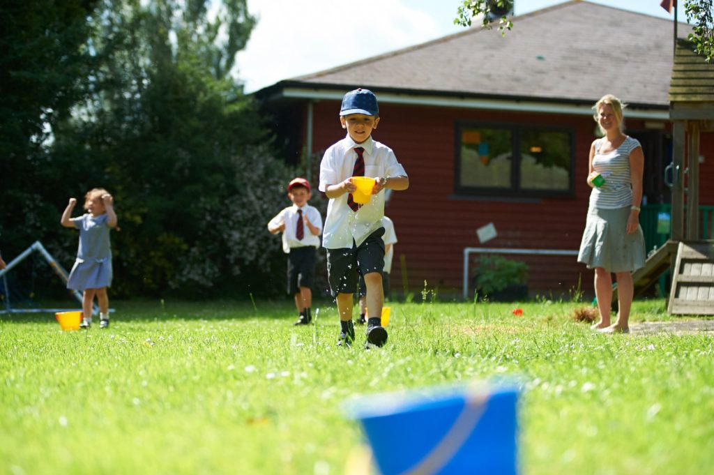 Some young pupils are pictured playing together with water in an outdoor area on the Paddock Wood Primary Academy premises.